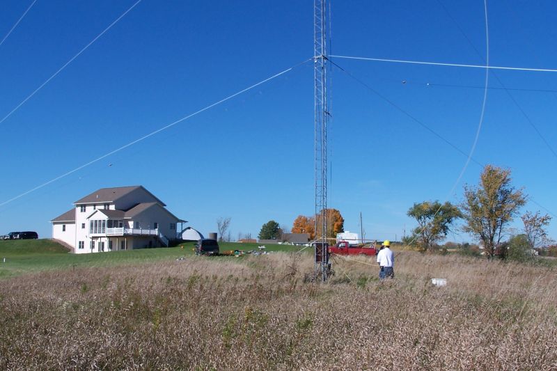 Home of KA9FOX in background.  Eric KB9TKF manning the ropes. Note how the wind is blowing the rope -- it got VERY windy in the 
