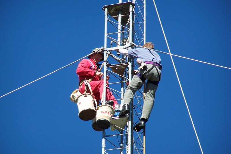 (L-R) Paul WØAIH and Chris KC9DGP working on tower.  Note guy wires are Polygon Fiberglass Rod.  Also note rope going