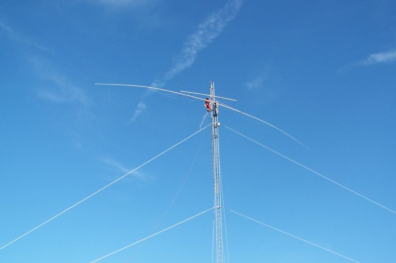 WØAIH and KC9DGP attach the Force 12 EF-180C 80m Rotatable Dipole to the mast.  The EF-180C is about 85 feet long.