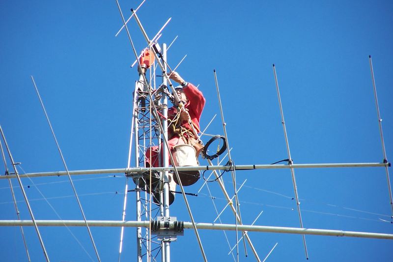 Paul WØAIH mounting 2 meter beam at the top of the mast.  Approximate height is 108 feet.
