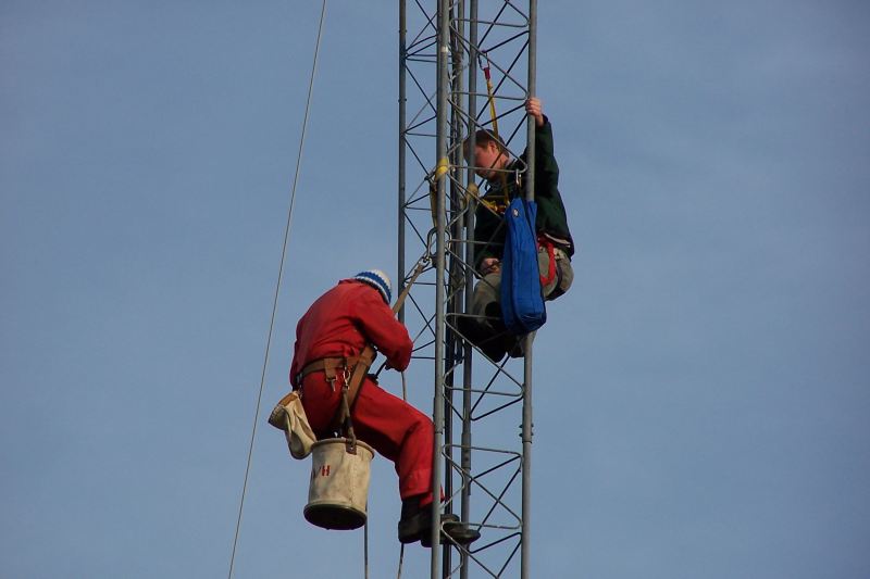 Paul WØAIH and Chris KC9DGP work on removing the Gin Pole made from Rohn 25.