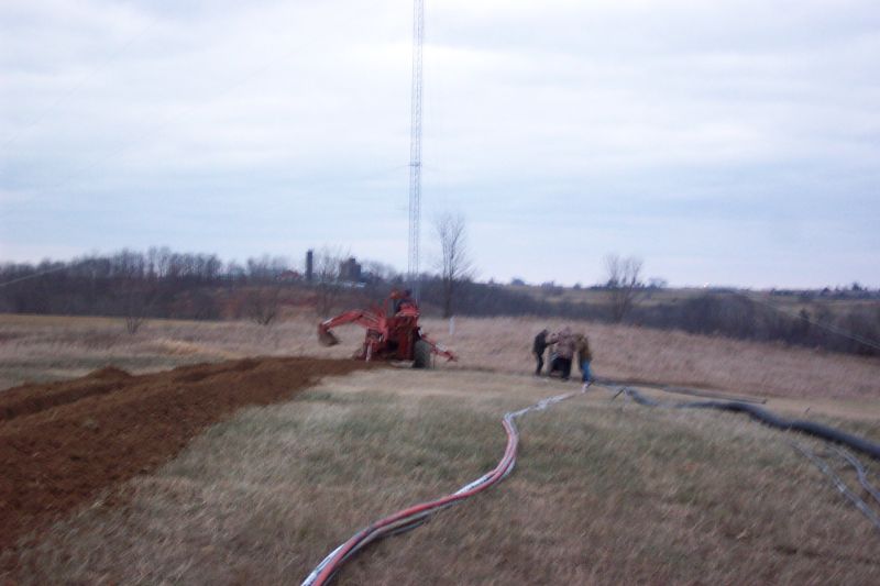 Trencher finishes up his work, while ground crew finishes rolling out hardline.