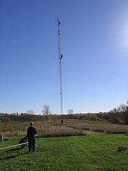 TOWER: Paul WØAIH on the Gin Pole with Chris KC9DGP below. GROUND: (l-r) Scott KA9FOX and Eric KB9TKF prepare 2m antenna for fin