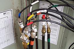 Close-up of the hardline coming from the tower, then transitioning to PolyPhaser lightning protectors, then to RG8-equiv into th
