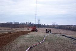 Trencher finishes up his work, while ground crew finishes rolling out hardline.